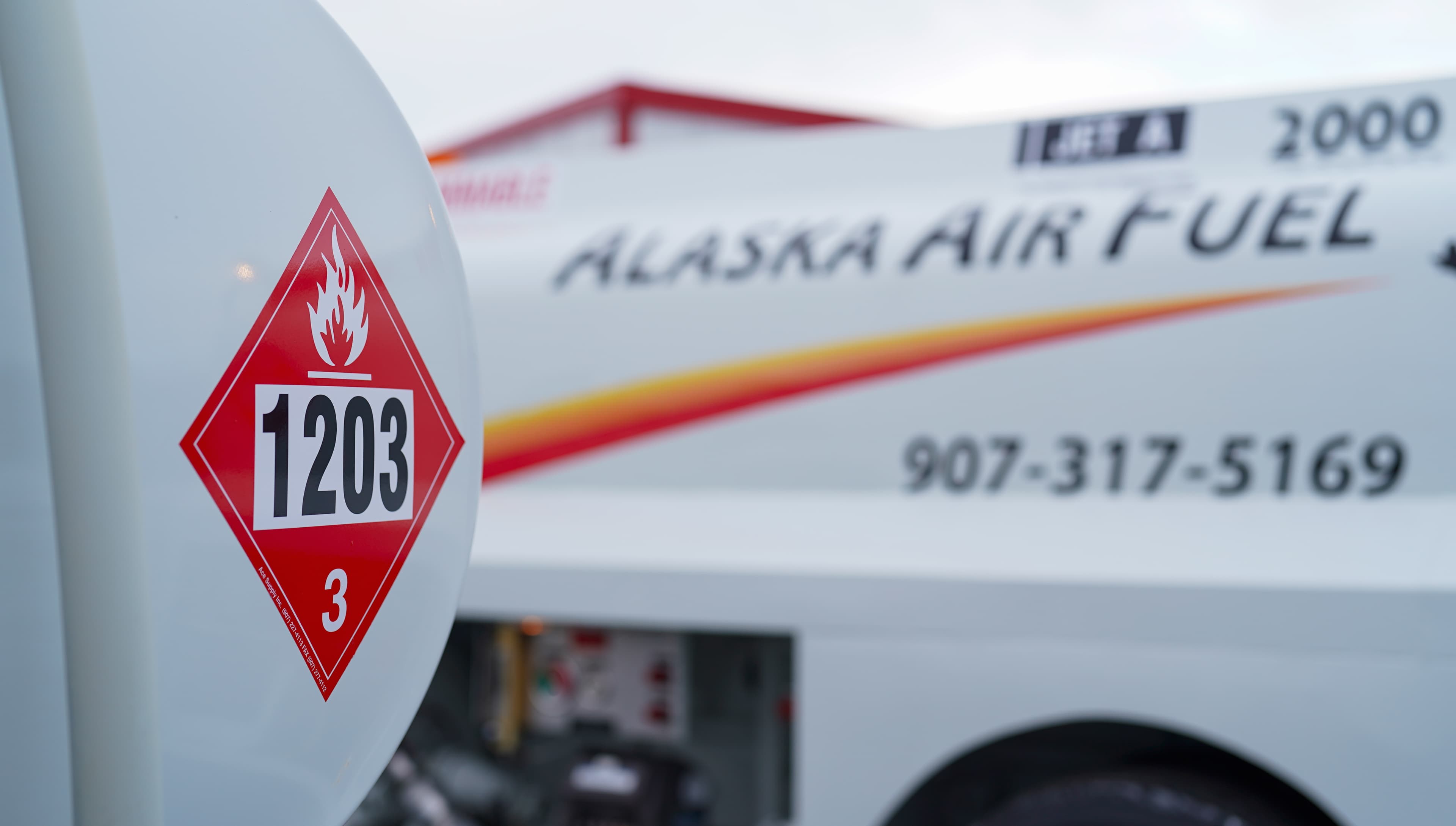 Flammable fuel placard with Alaska Air Fuel truck in background